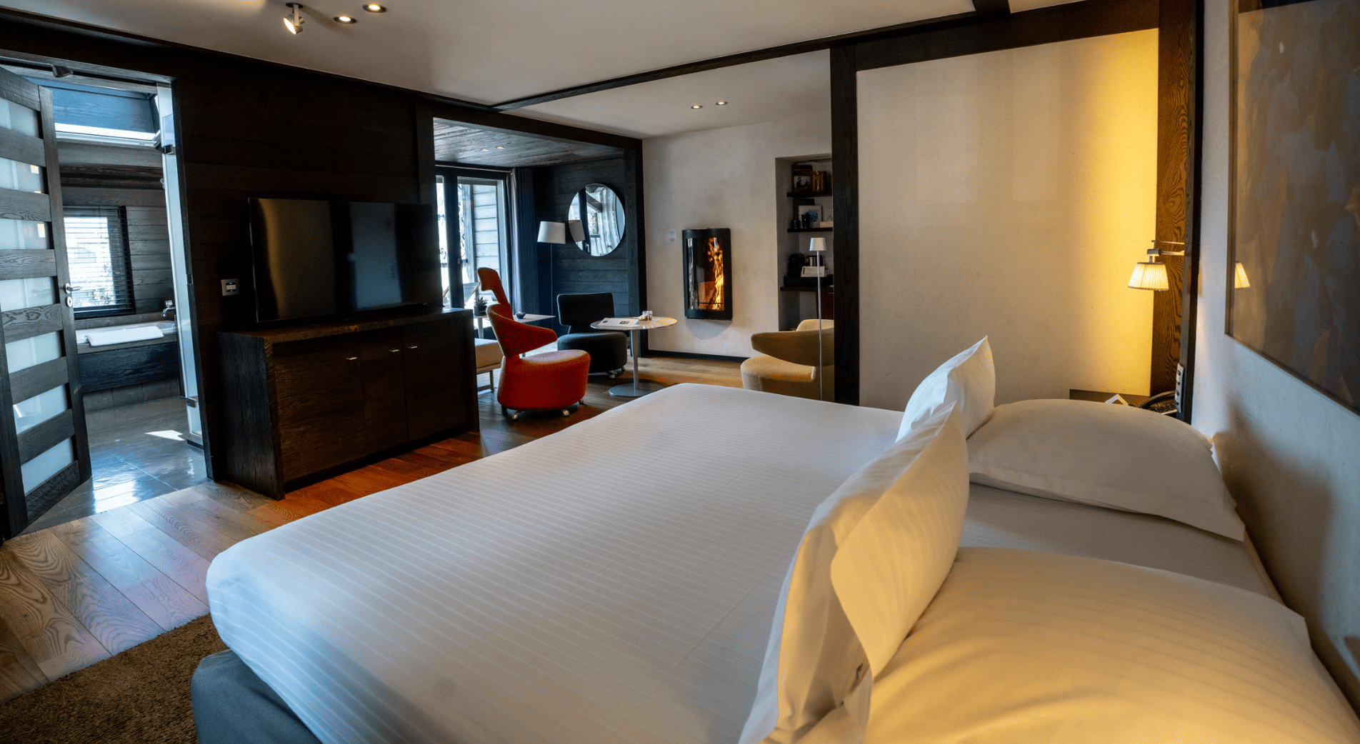 Vue de la salle de bain, cheminée, literie et coin salon cheminée de la chambre luxe avec cheminée à l'albert 1er