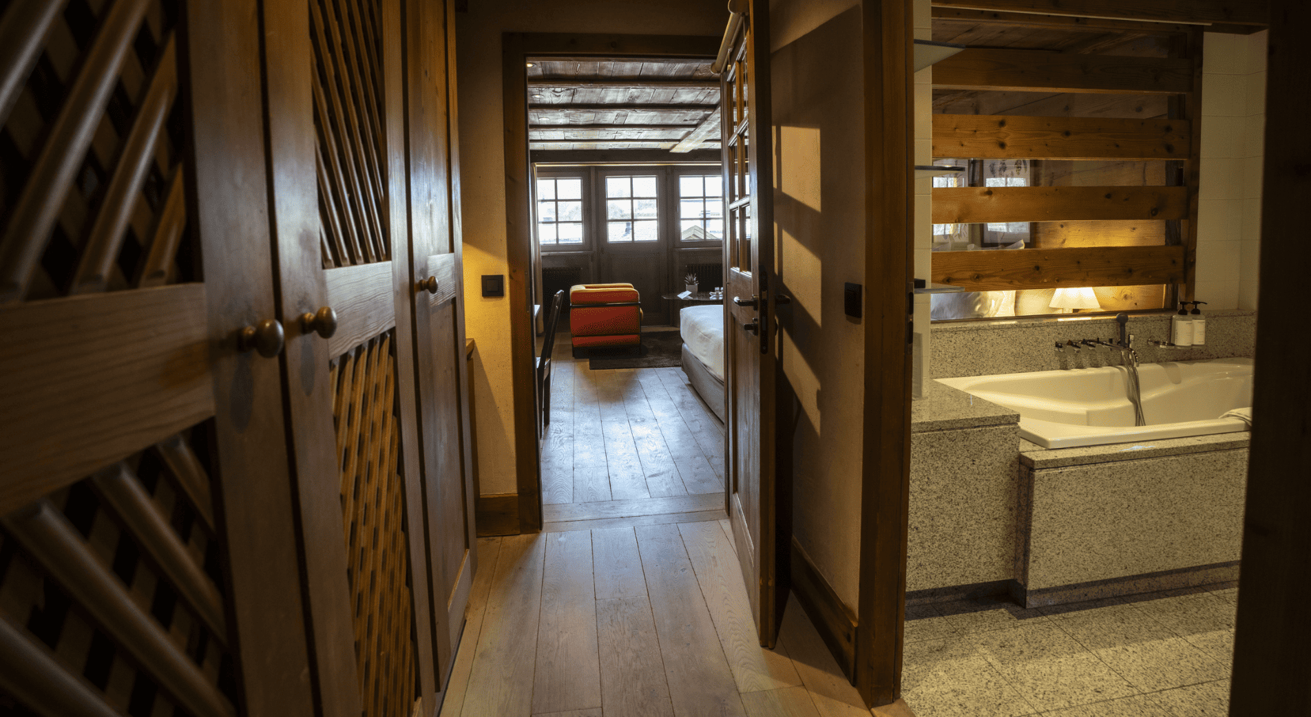 Vue depuis le couloir sur la salle de bain et sur la chambre luxe avec cheminée à la ferme