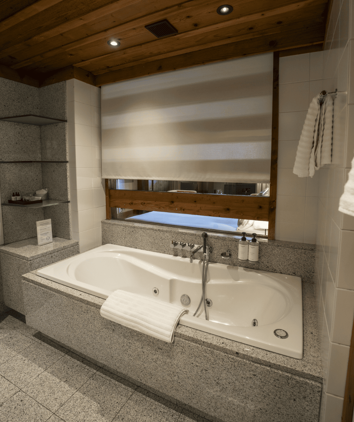 Salle de bain et baignoire balnéo de la chambre luxe avec cheminée à la ferme