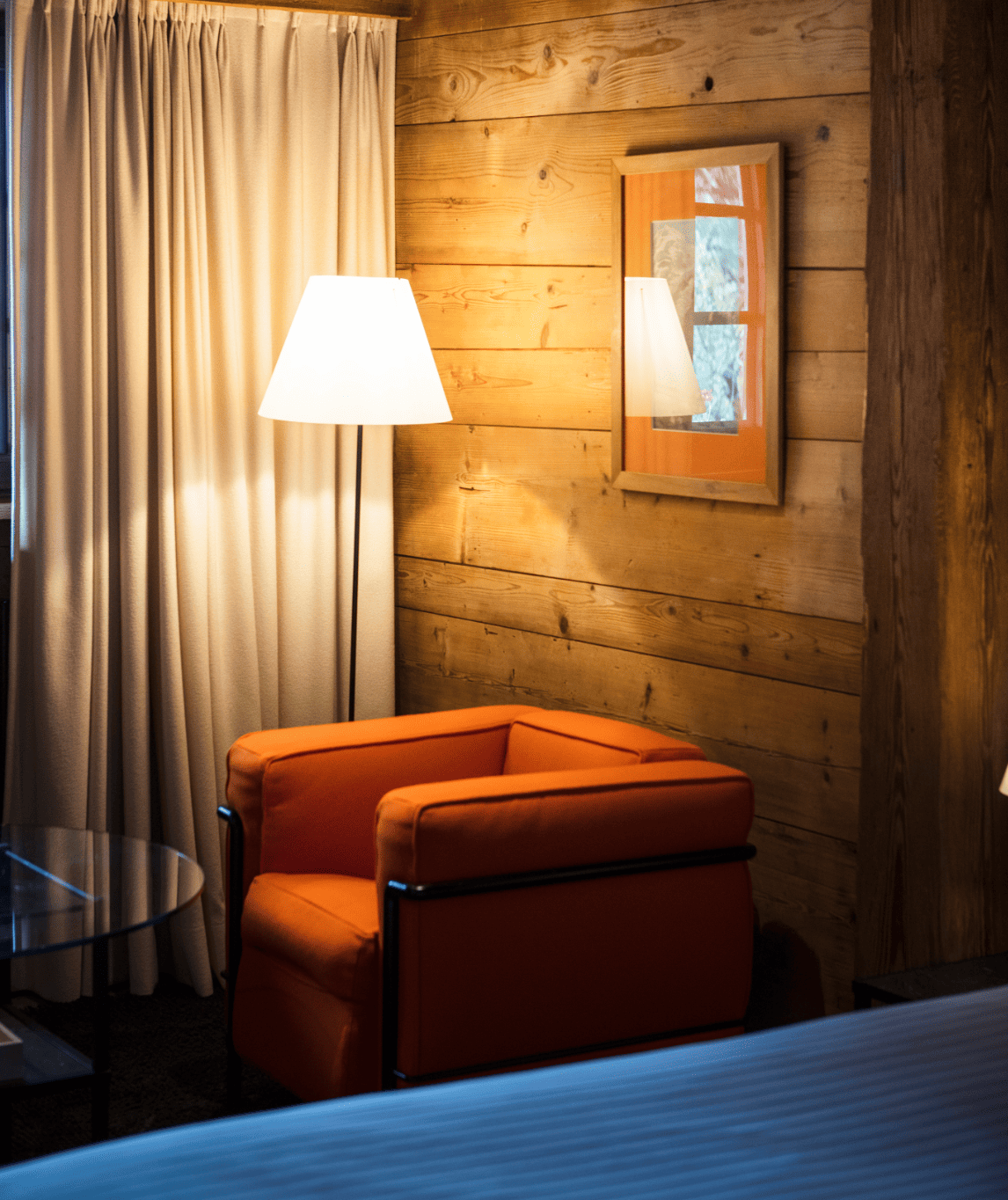 Coin salon éclairé par une lampe design dans la chambre luxe sans cheminée à la ferme
